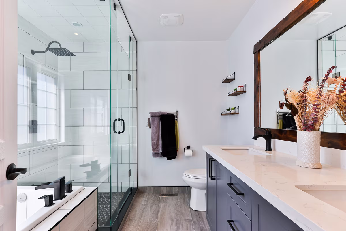 Modern transitional bathroom featuring black fixtures, white subway tiles, and navy blue vanity with natural accents