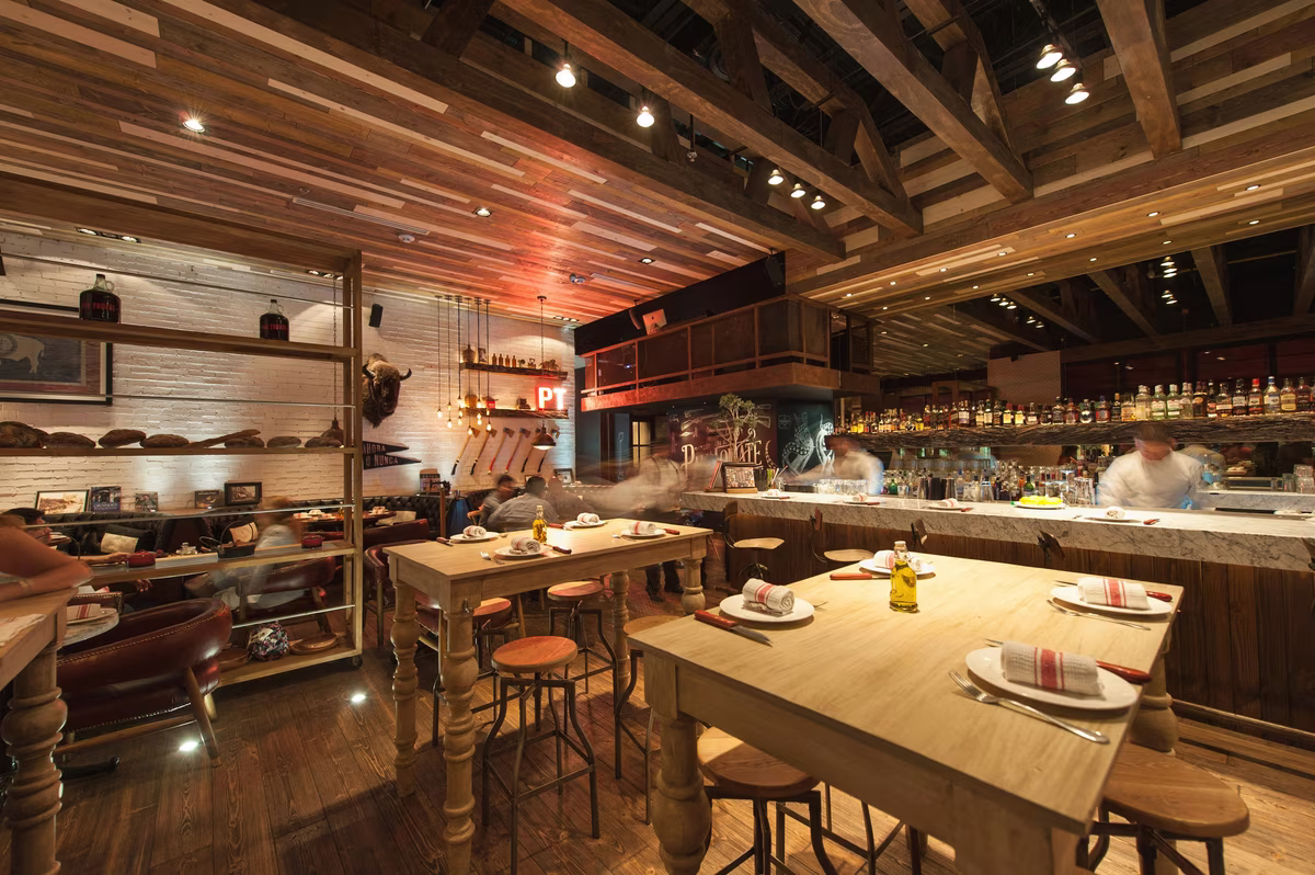 Rustic industrial restaurant with wooden beams, exposed brick walls, and eclectic decor