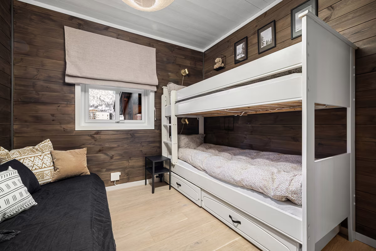 Modern kids room with dark wood paneled walls and white bunk bed