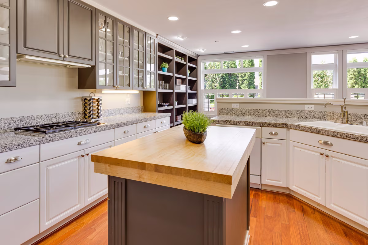 Transitional L-shaped kitchen with solid wood island and custom display wall