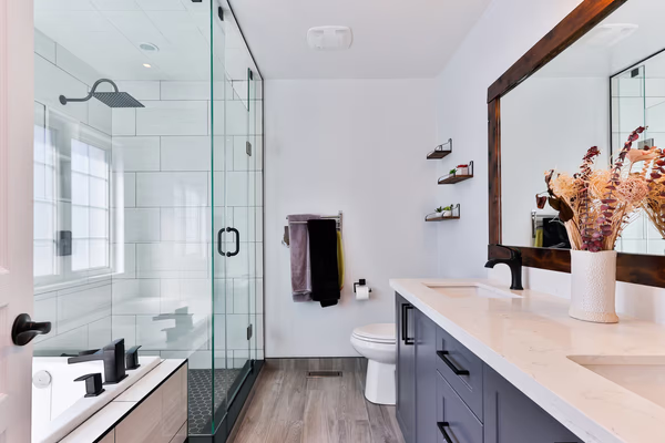 Modern transitional bathroom featuring black fixtures, white subway tiles, and navy blue vanity with natural accents