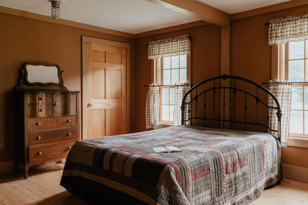 Traditional heritage guest bedroom with vintage furniture and handmade quilt