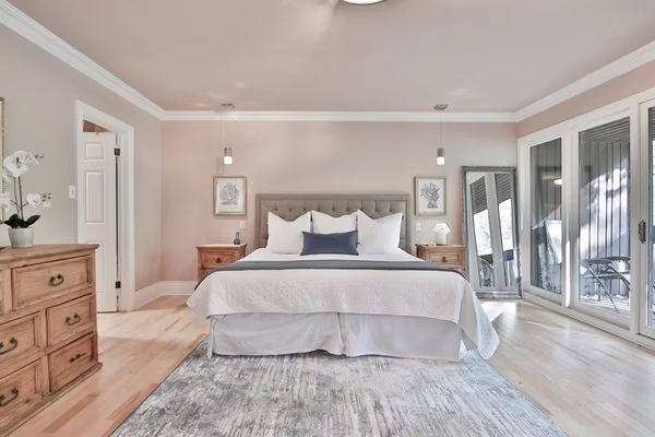 Coastal French bedroom with blush walls and rustic furniture