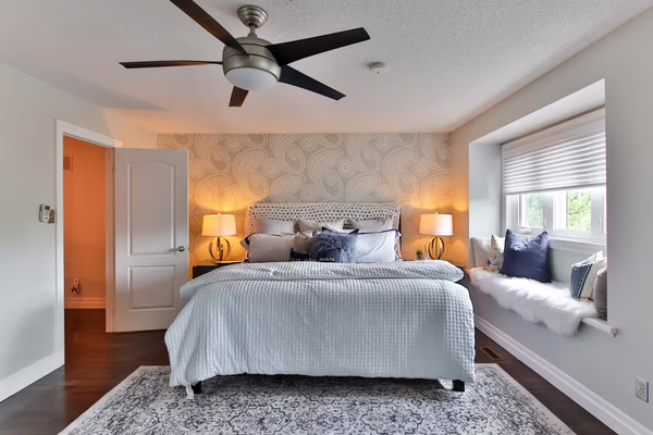 Transitional bedroom with navy accents and built-in window seat