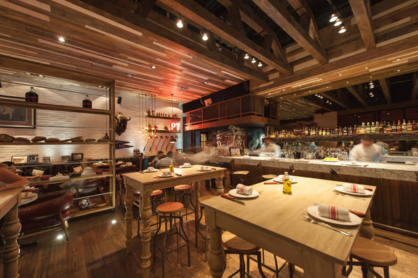 Rustic industrial restaurant with wooden beams, exposed brick walls, and eclectic decor