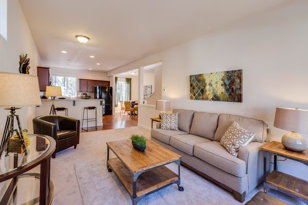 Open concept living room with industrial style furniture and neutral tones