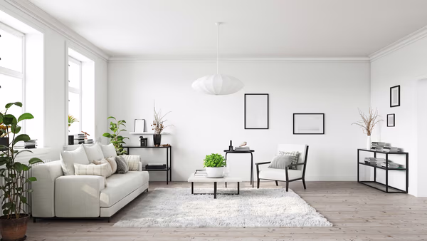 Minimalist white living room with sculptural pendant light and black accents