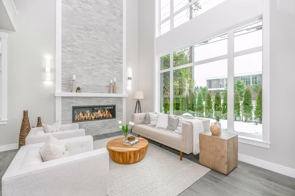 Modern living room with floor-to-ceiling stone fireplace and white furniture