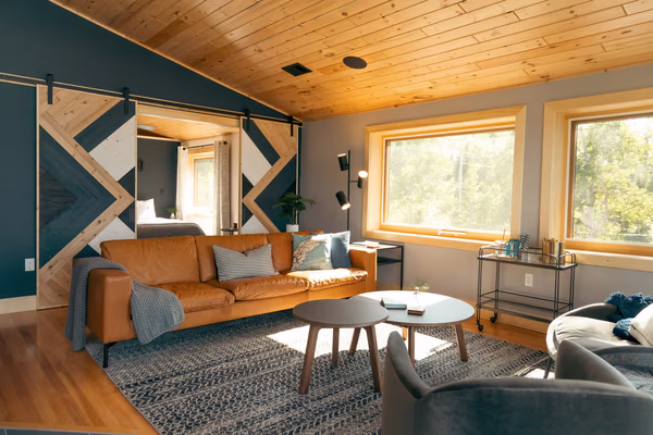 Modern living room with geometric accent wall and wooden ceiling