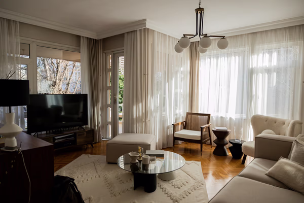 Bright modern living room with globe chandelier and sheer curtains