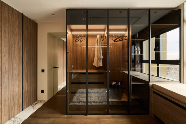 Modern wardrobe with smoked glass doors and illuminated wood interior